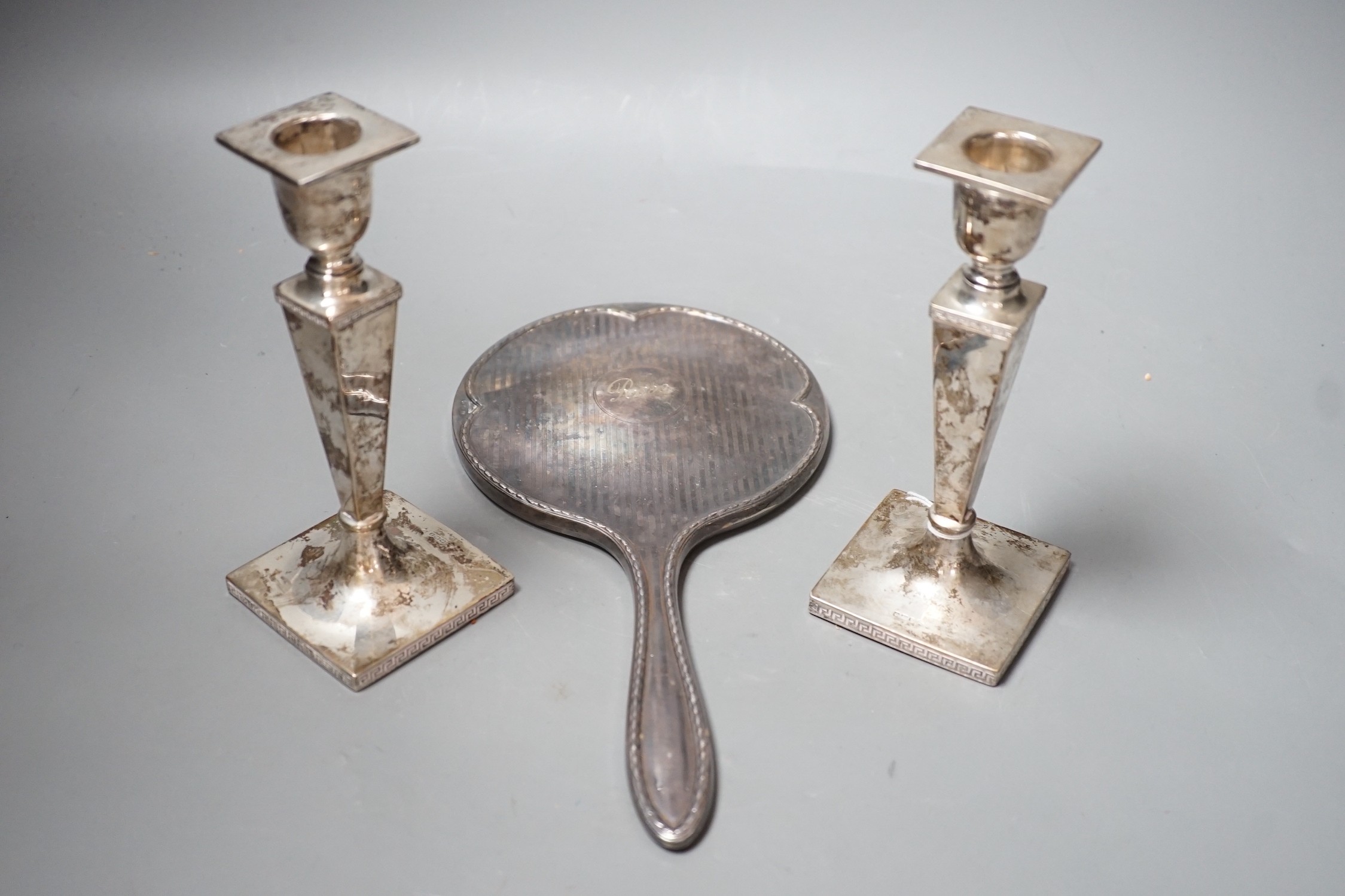 A pair of George V silver candlesticks, with tapering stems, Walker & Hall, Sheffield, 1915, 16.4cm, weighted and a 1920's silver mounted hand mirror.